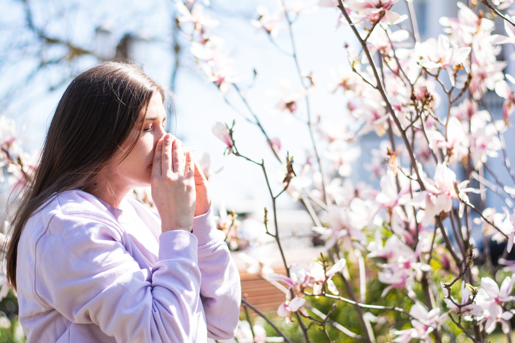 Woman suffers from seasonal allergy to pollen in the open air in the park