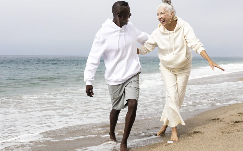 Happy senior couple relaxing at the beach in winter